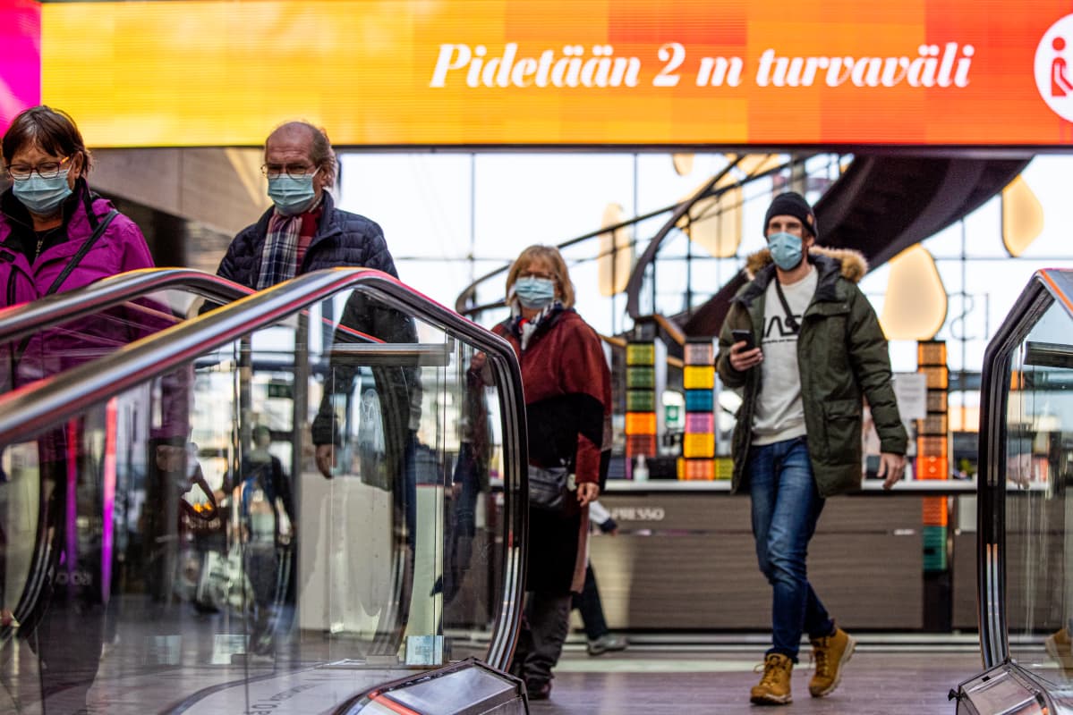 Henkilöitä kauppakeskuksessa.