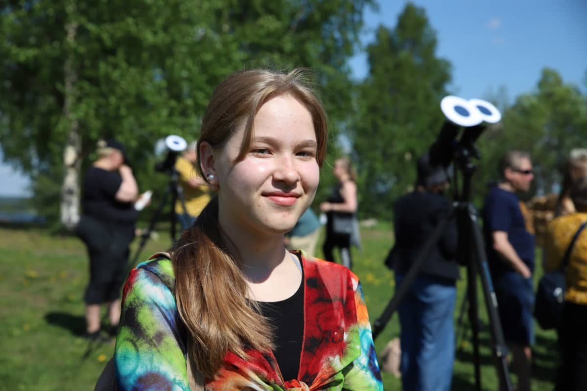 Nuori nainen katsoo auringonpimennystä rovaniemellä aurinkoisessa säässä