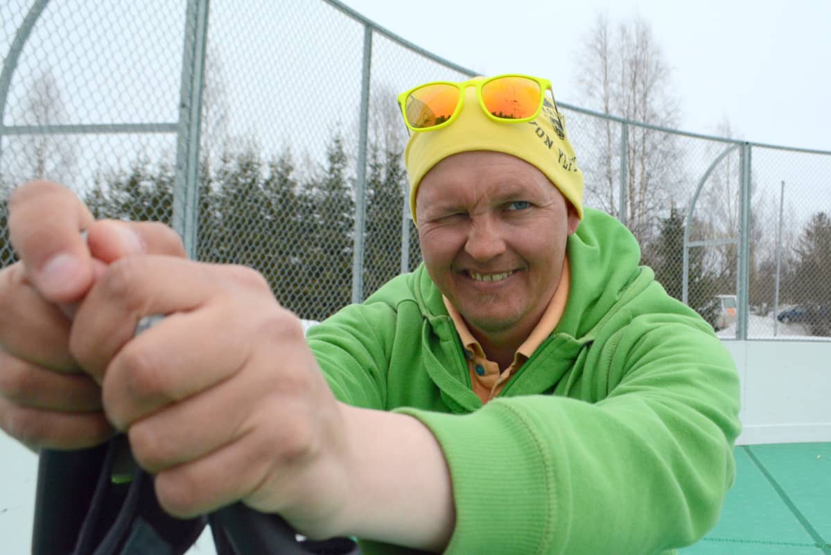 Pasi Raatikainen nojaa hiihtosauvoihin ja iskee silmää