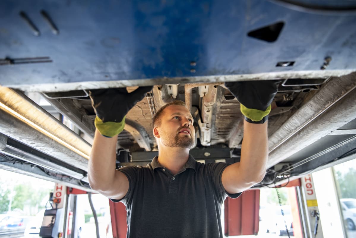 Autokatsastaja Tommi Pasanen tarkastaa katsastettavaksi tulleen auton pohjaa
