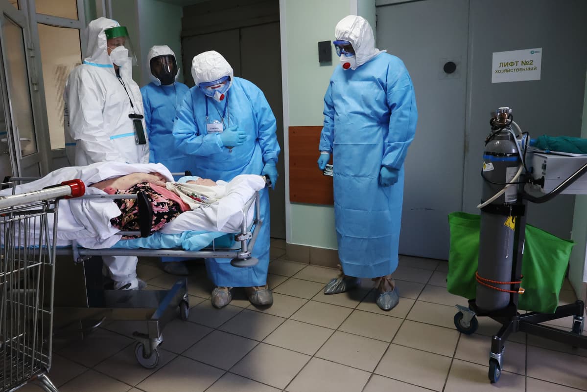 Suoja-asuihin pukeutuneet henkilöt juttelivat potilaalle moskovalaisessa sairaalassa marraskuussa.