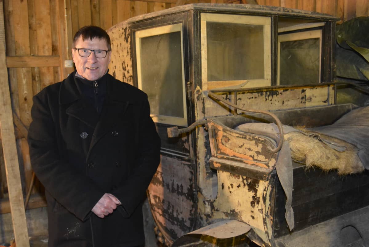 Vanhat hevosvaunut rapistuvat Kyminlinnan entisen varuskunnan varastossa. Vaunujen vieressä tietokirjailija Risto Valkeapää.