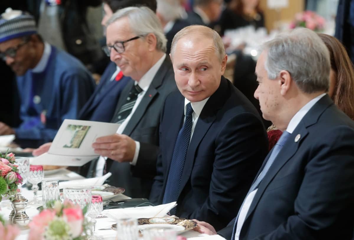 Vladimir Putin lounaalla ensimmäisen maailmansodan päättymisen muistojuhlallisuuksissa. Oikealla YK:n pääsihteeri Antonió Guterres ja vasemmalla puolella EU:n komission puheenjohtaja Jean-Claude Juncker.