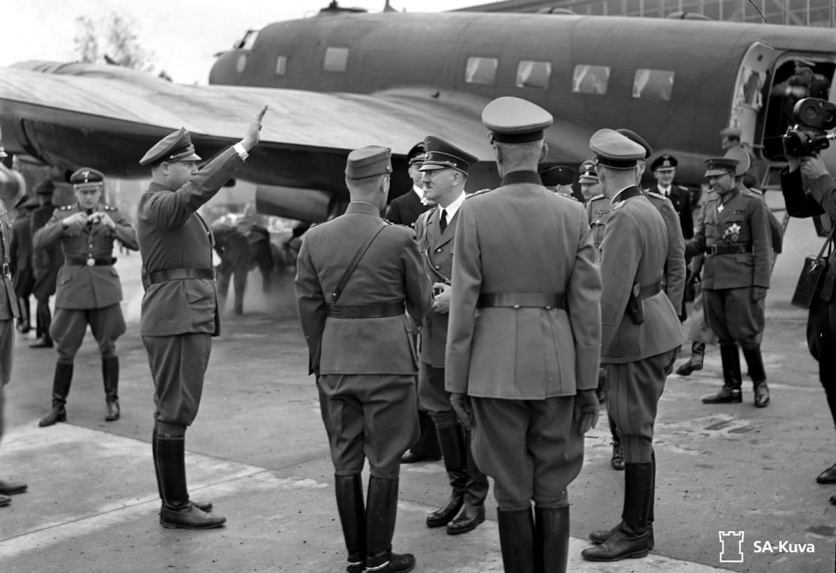 Adolf Hitler saapuu Immolaan. Taustalla lentokone.