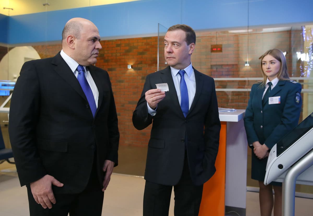 Veroviraston aulassa johtaja Mihail Misustin ja Dmitri Medvedev, joka pitelee kädessään kuittia.