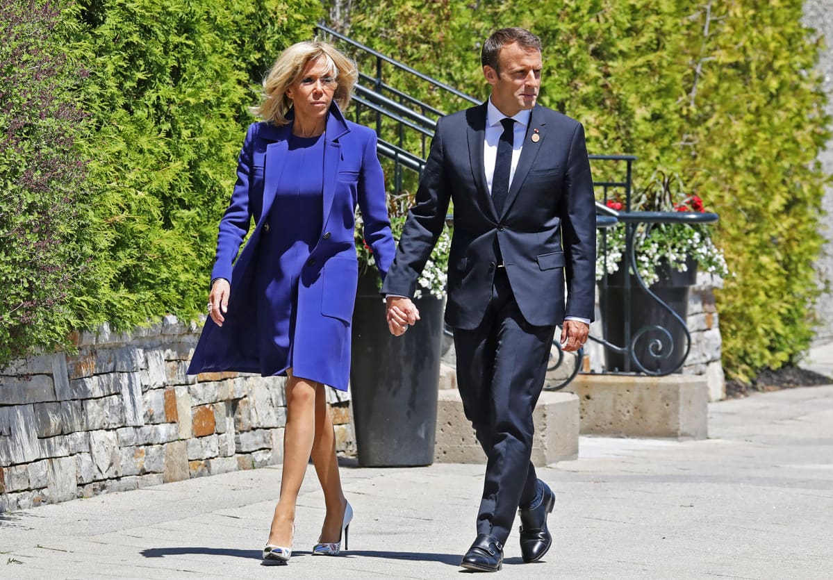Emmanuel ja Brigitte Macron käsi kädessä.