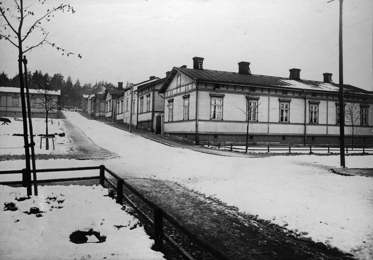 Puuvillatehtaankadun länsipää vuonna 1913. Mustavalkoinen kuva otettu talviaikaan, mutta lunta on vain vähän. Katua reunustavat työväen puukorttelitalot.