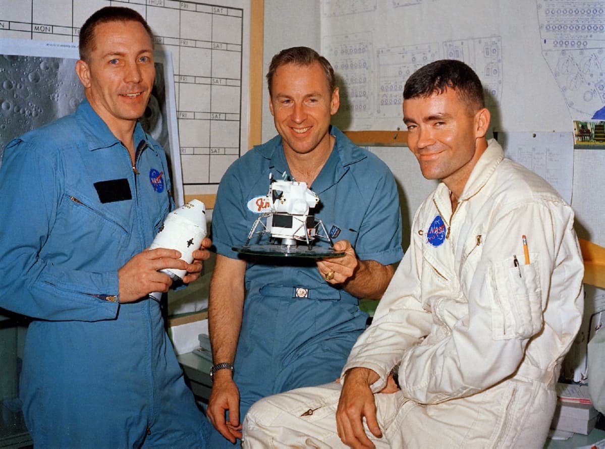 Kolme astronauttia Nasan haalareissa, Haise ja Swigert pitelevät Apollo 13:n pienoismallia.