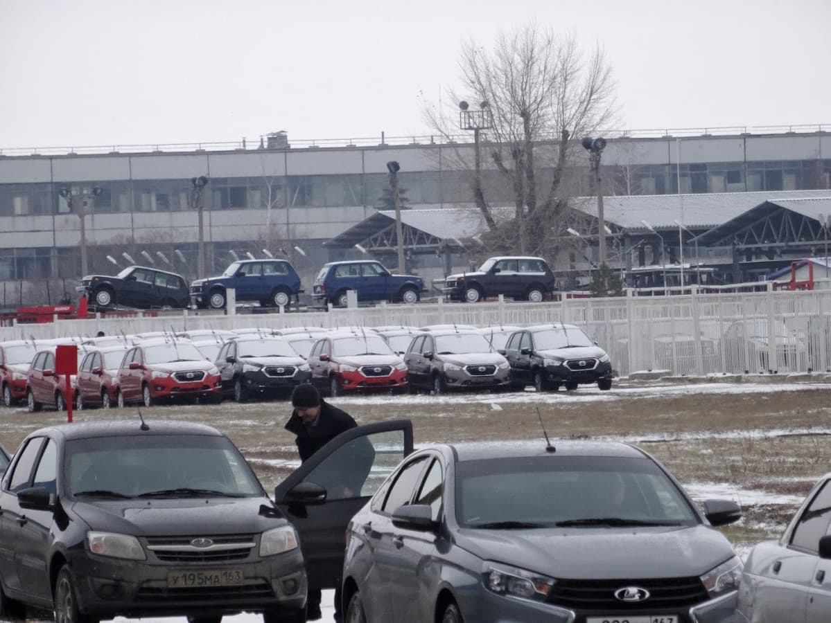 Tehtaan pihalla seisoo autoja valmiina markkinoille.
