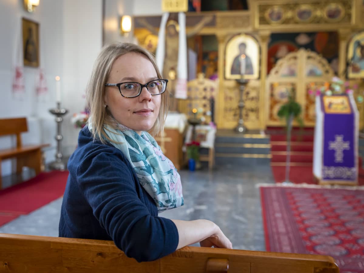 Elina Ruuttila istuu kirkon penkissä.