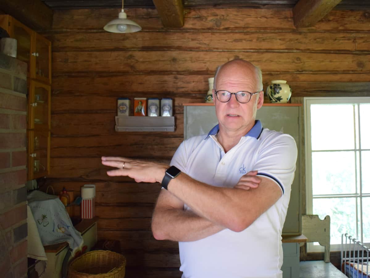 Reijo Karhinen yhden kokoamansa hirsitalon sisäsllä.