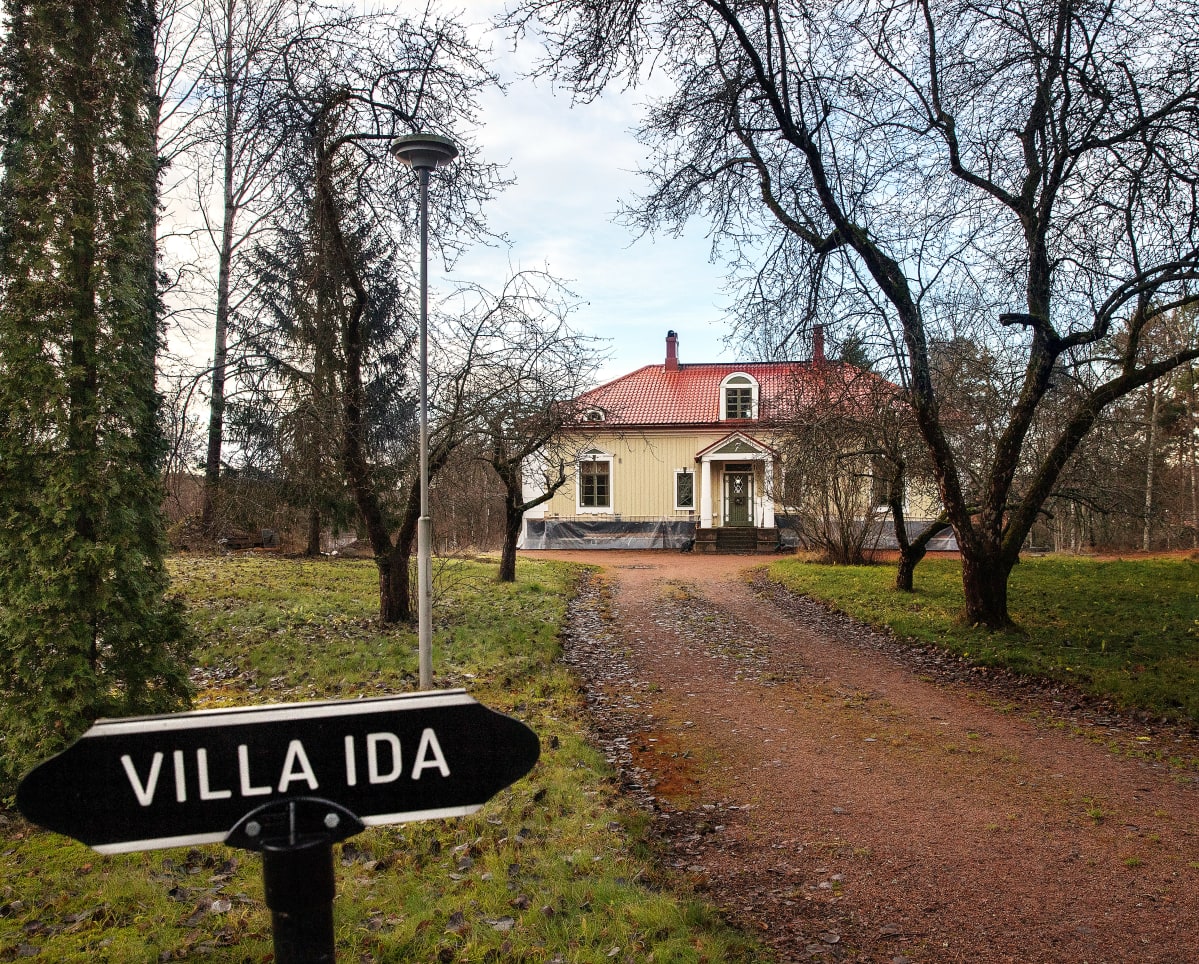 Kyltti: Villa Ida ja taustalla talo