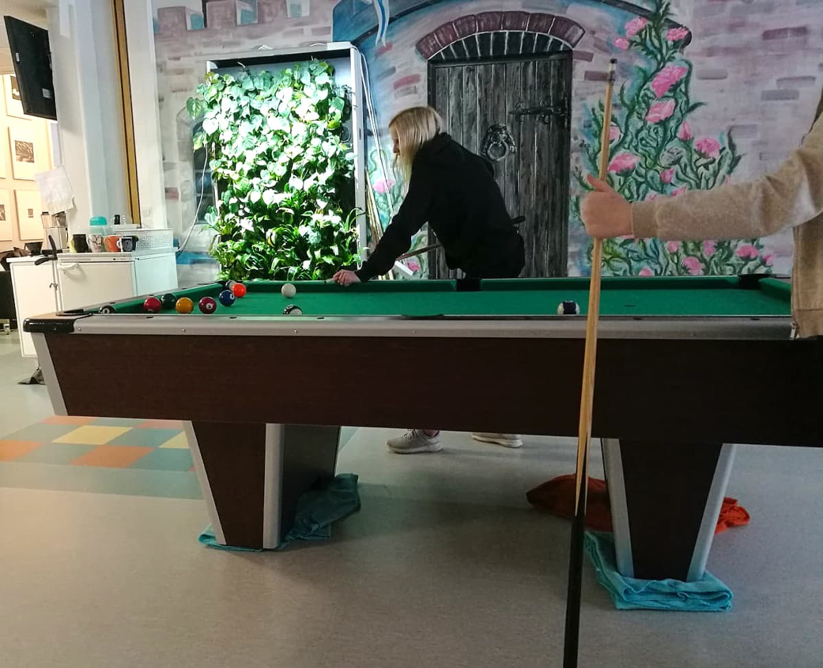 Kuvassa nuori pelaa biljardia.