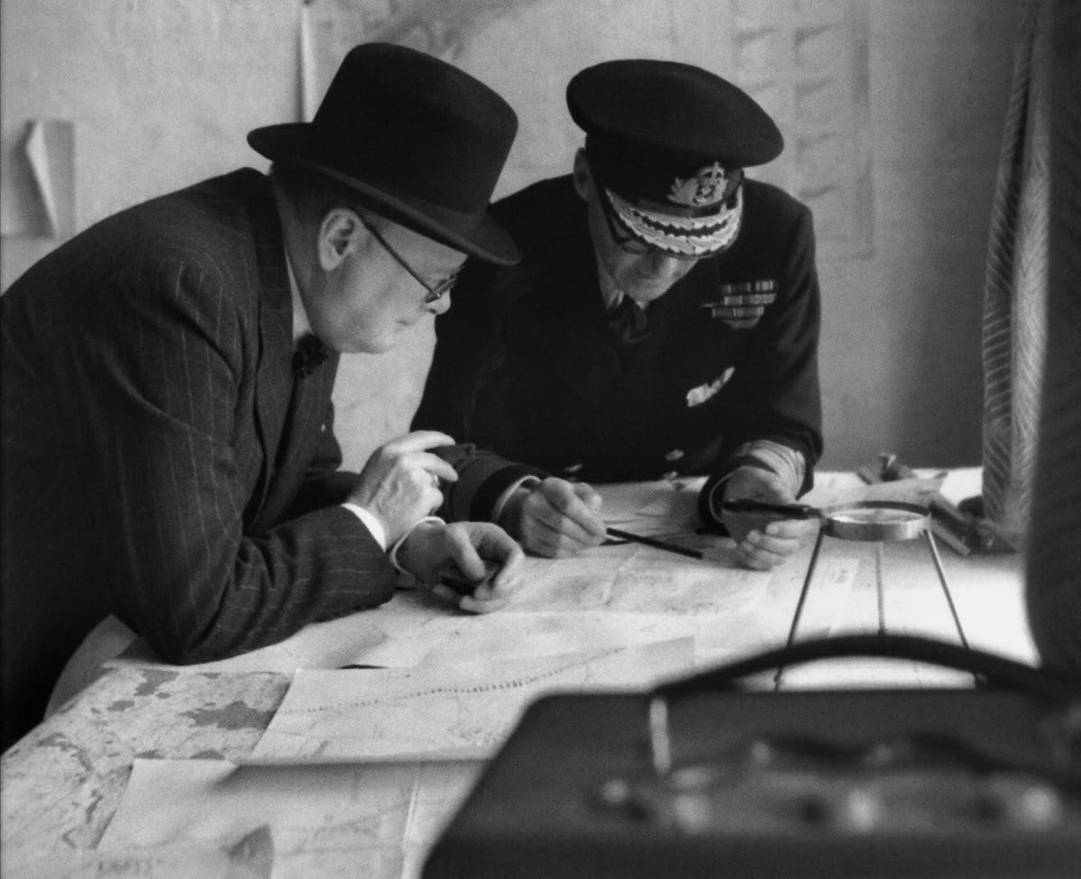 Pääministeri Winston Churchill ja amiraali Bertram Ramsey tutkivat karttaa.
