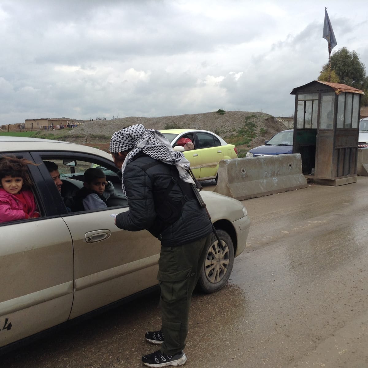 Derikin ulkpuolella turvallisuusjoukkoihion kuuluva nainen tarkistaa ajoneuvoja.