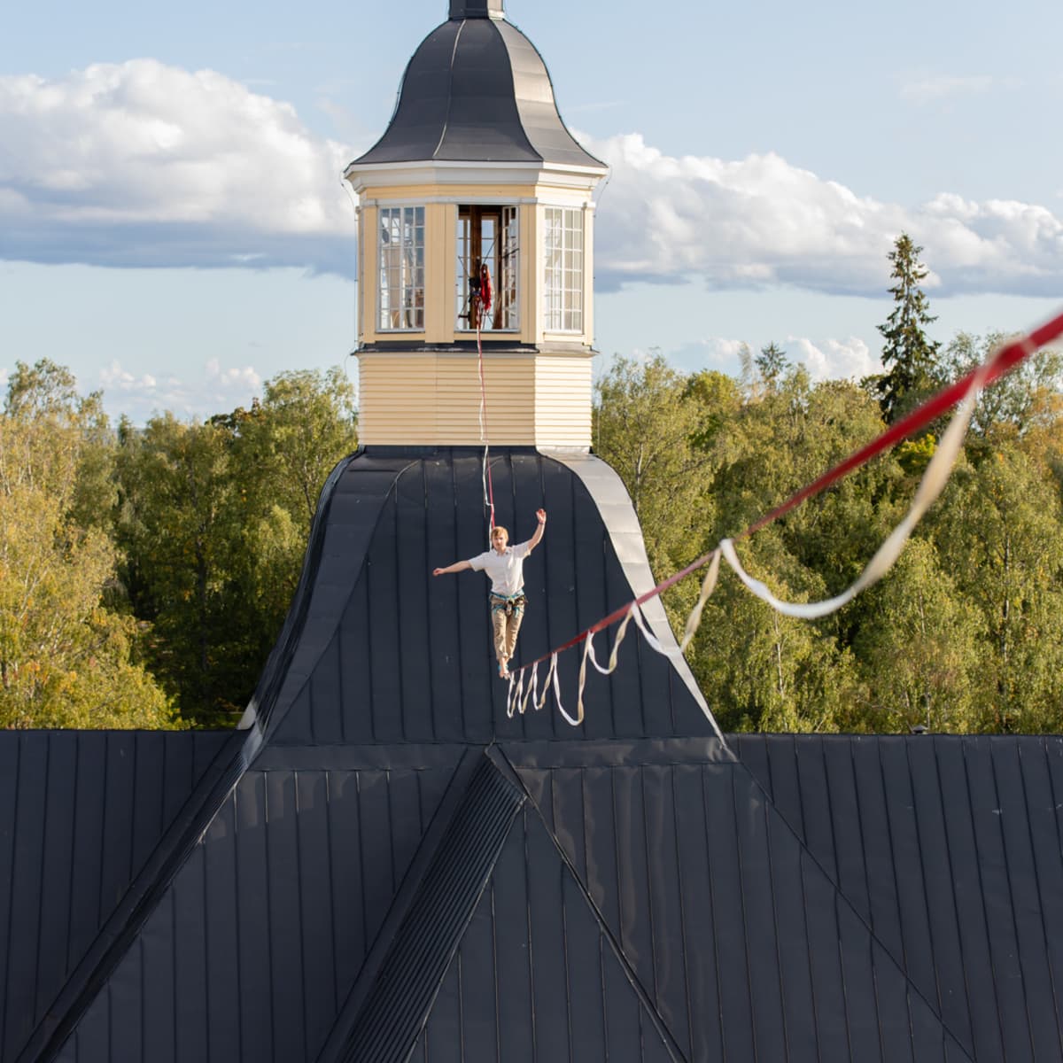 Slackline-harrastajia Lappeen Marian kirkon ja Osuuspankin kattojen väliin viritetyllä liinalla.