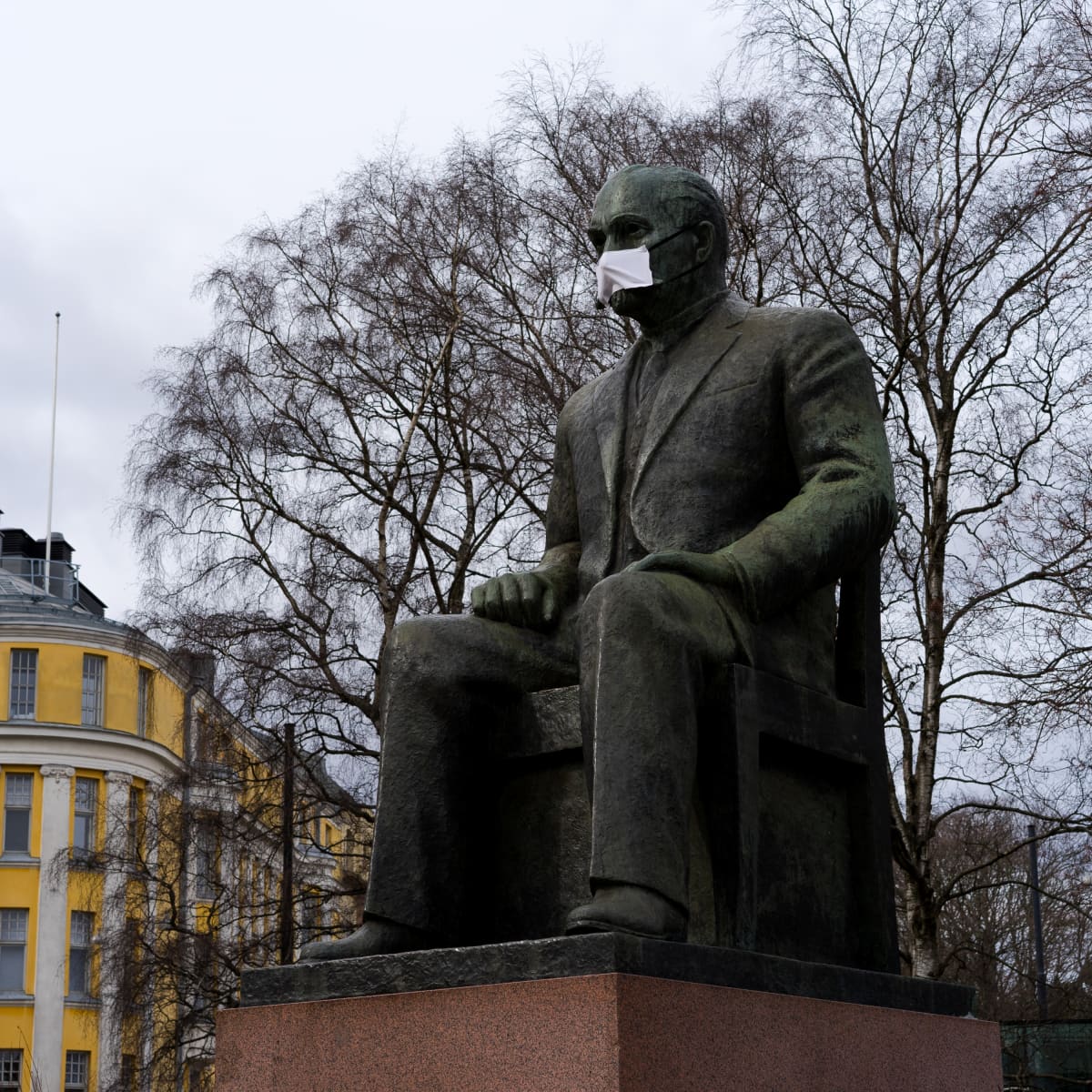 Kyösti Kallion patsas eduskuntatalon edessä hengityssuojan kanssa 31.3.2020.