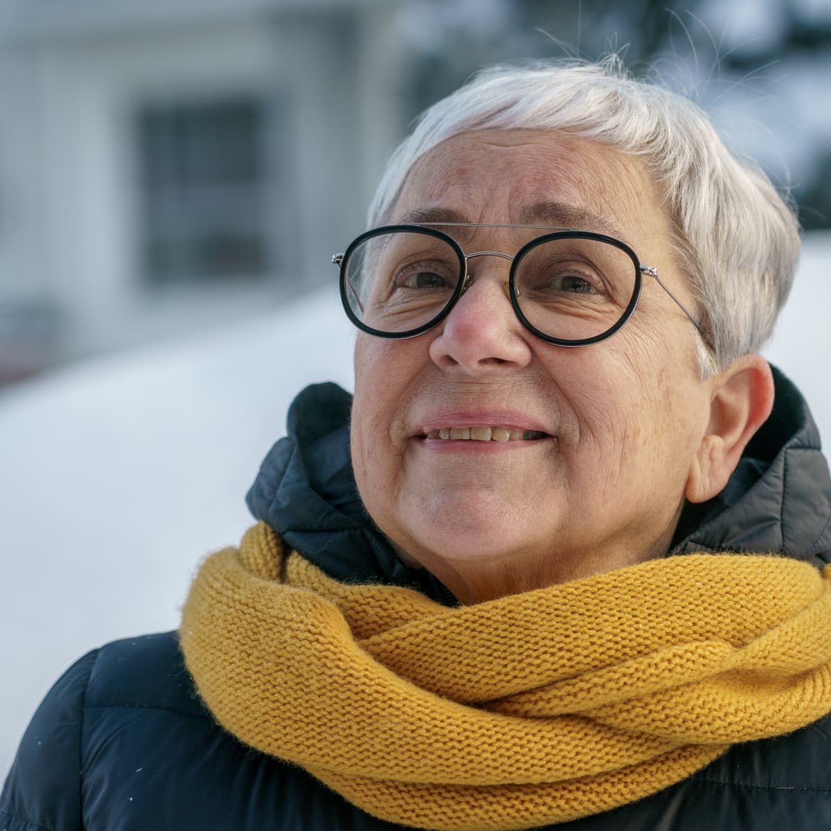 Omaishoitaja Marja-Liisa Saarinen ulkovaatteissa henkilökuvassa.