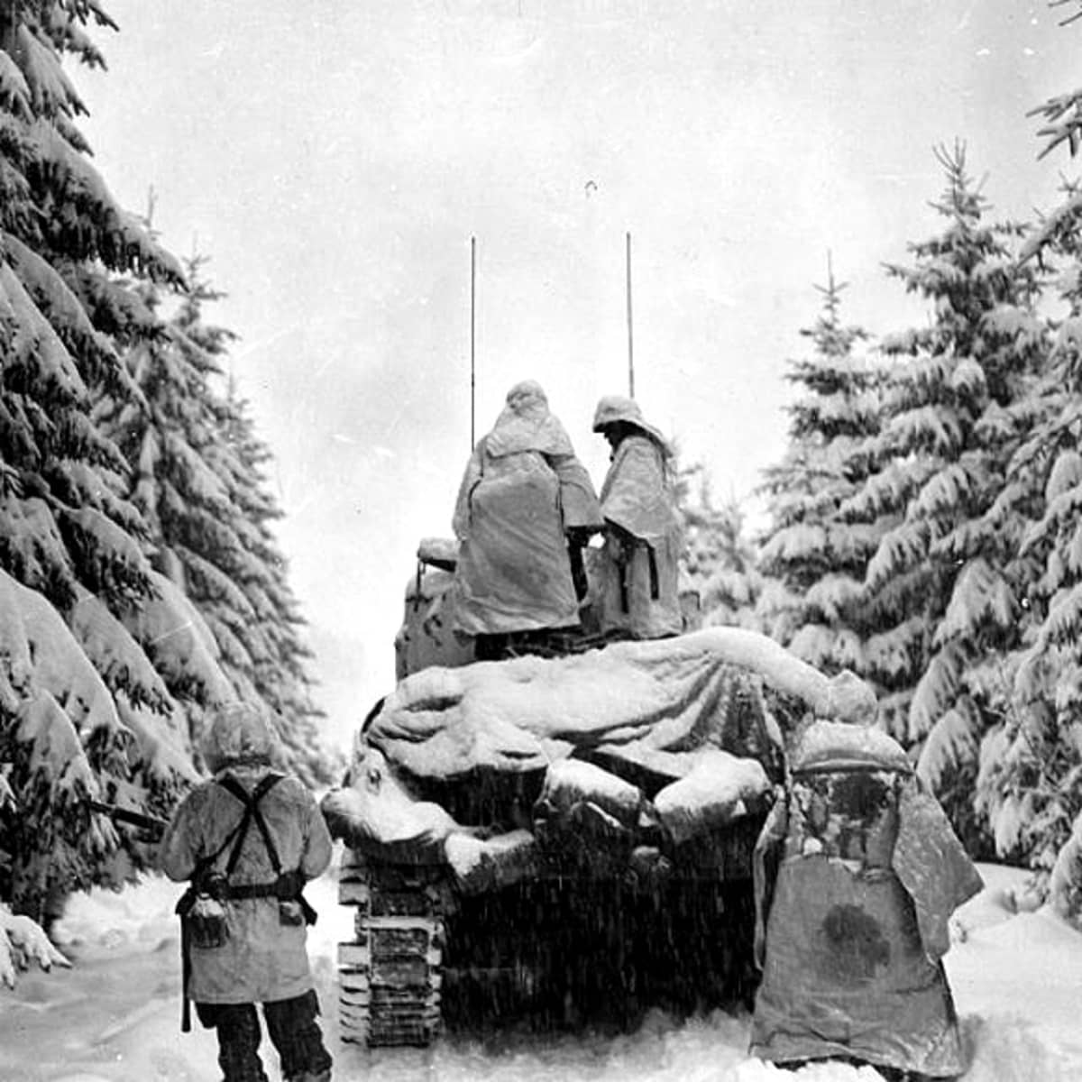 Yhdysvaltain armeijan panssarivaunu ja sotilaita etenemässä Ardennien taistelun aikana.