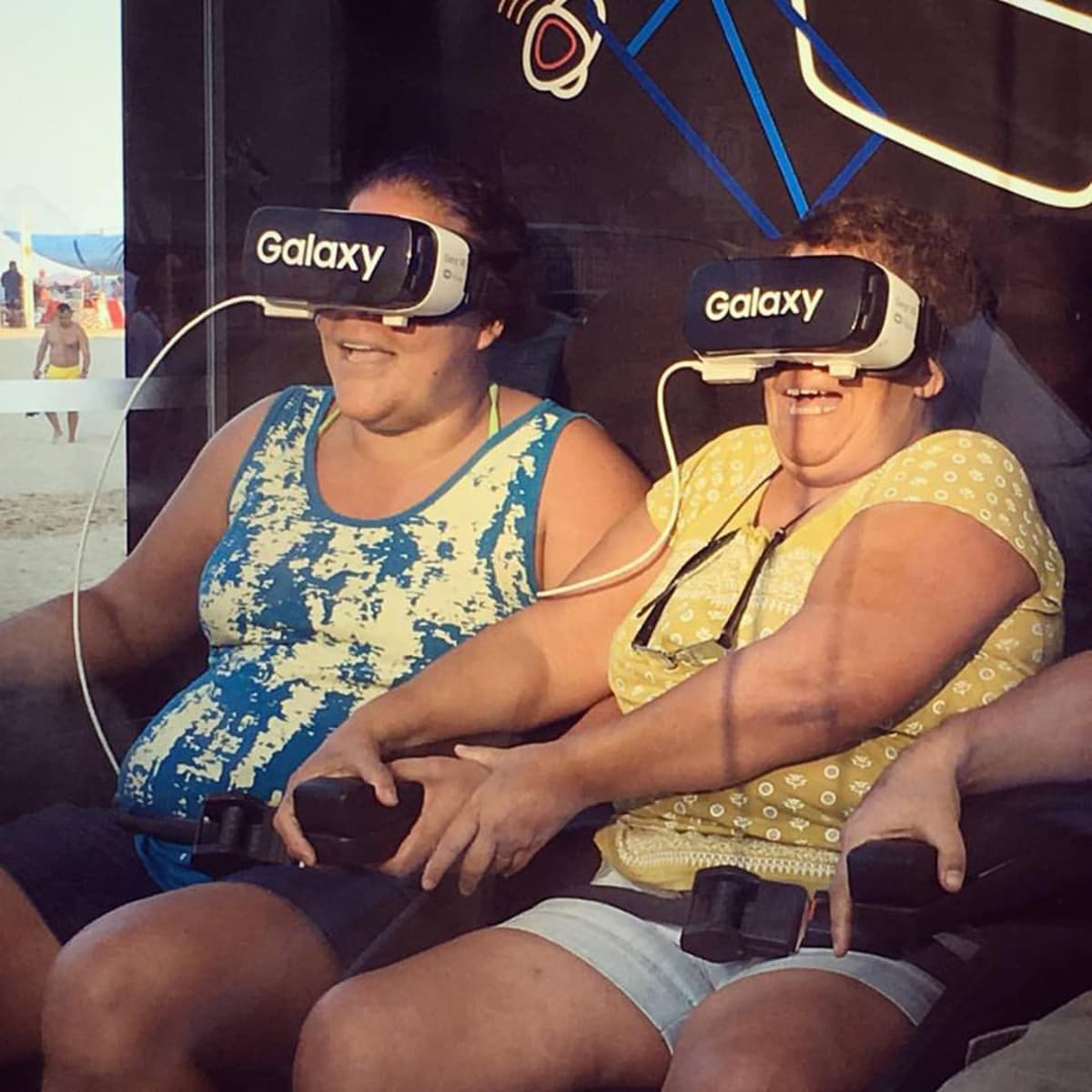 Naiset tutustumassa virtuaalitodellisuuteen olympialaisriehan keskellä.