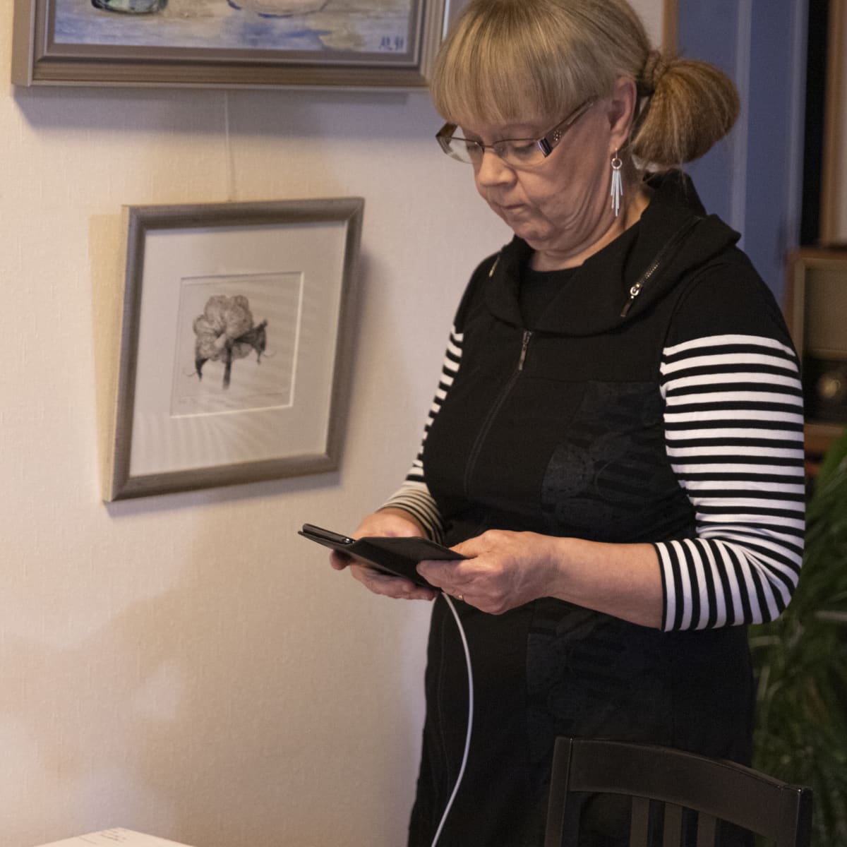 Kirsti Sandell tutkii matkapuhelintaan.