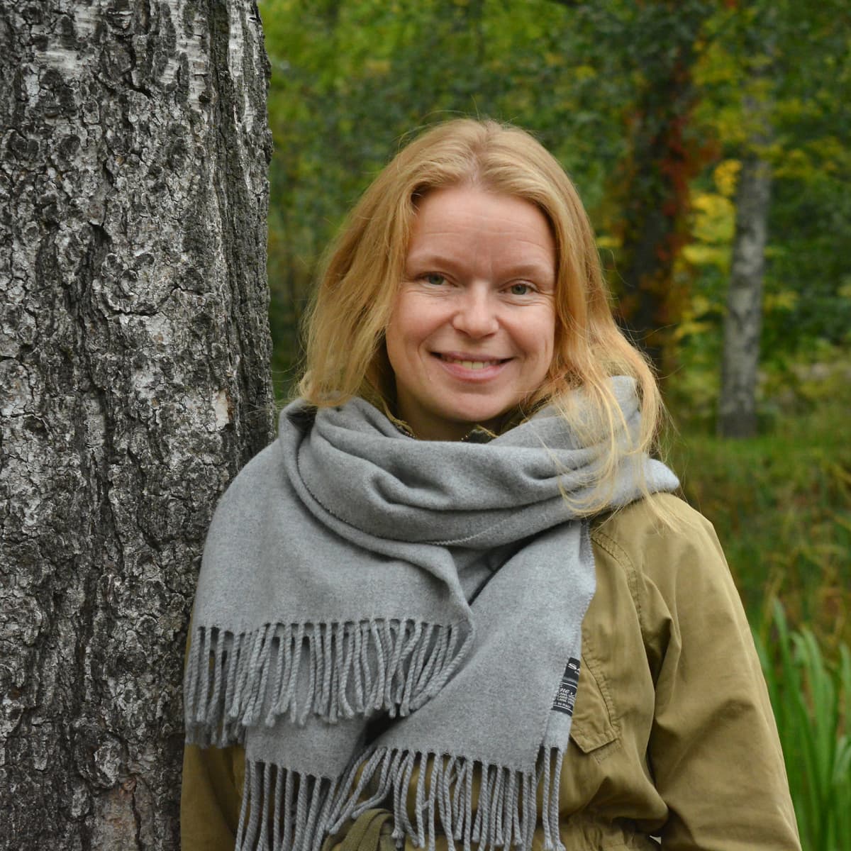 Mai Suominen seisoo puun vieressä.