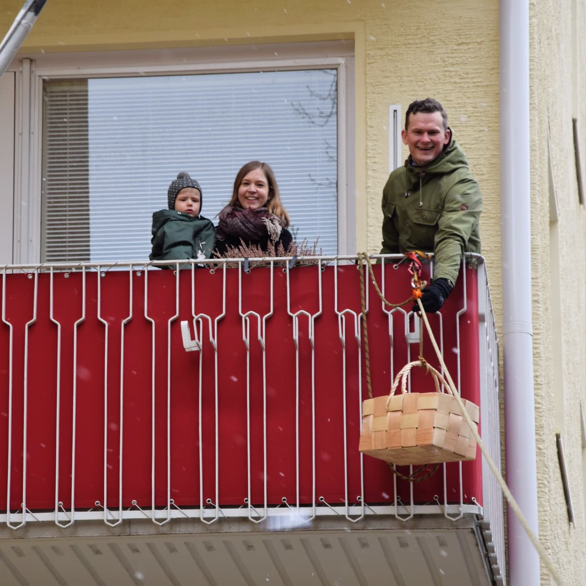 Niko Vähäsarja laittaa virpomispalkkiot korilla köyttä pitkin lapsille pihaan.