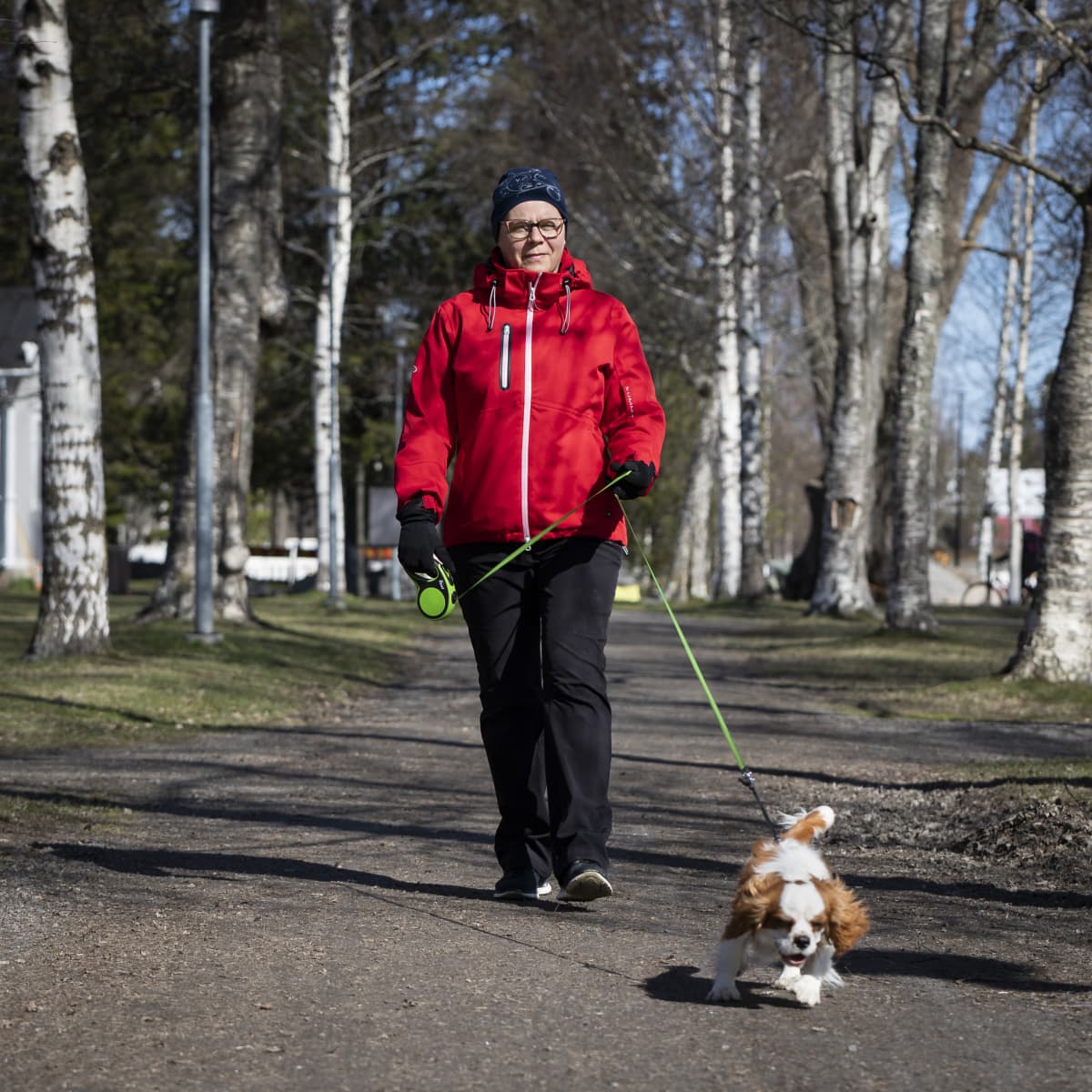 Pia Björkgren ulkoiluttaa koiraansa puistoalueella.