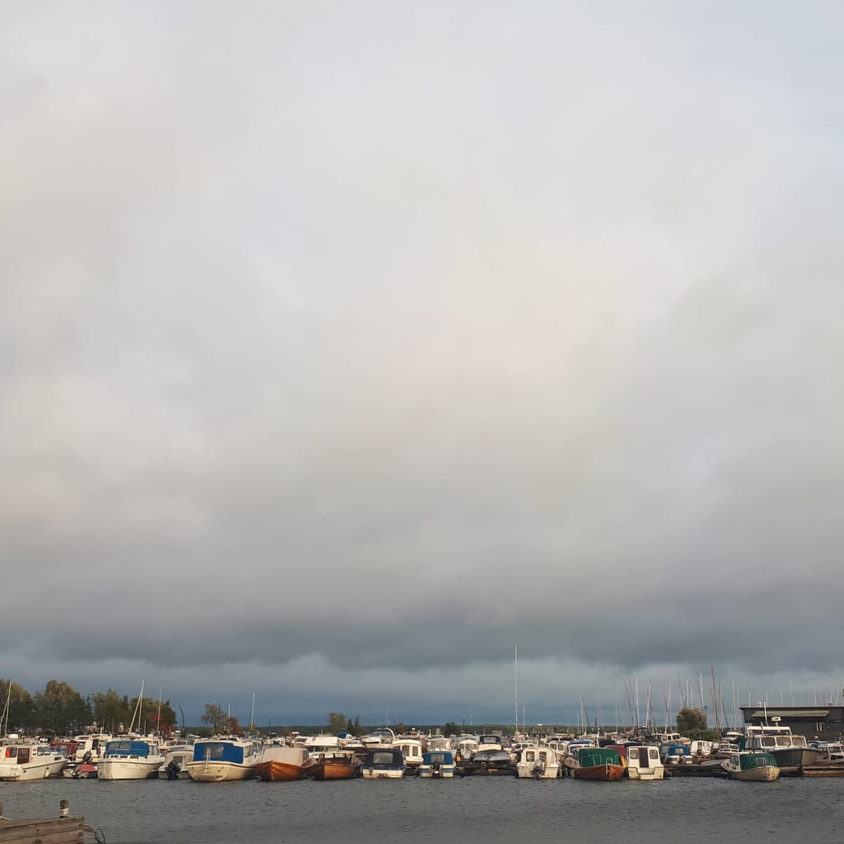veneitä satamassa tumman taivaan alla