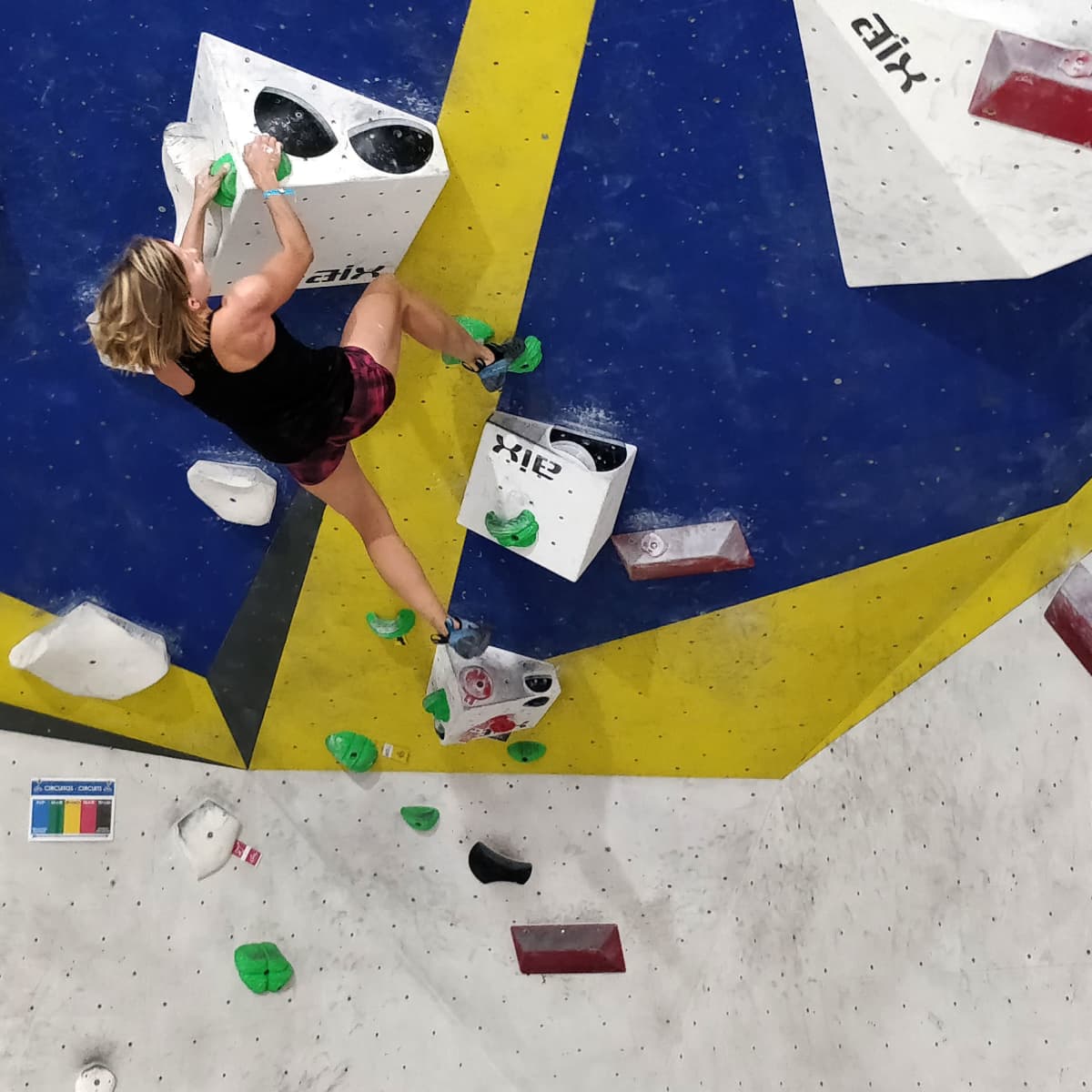 Jenni Christiansen kiipeää sisäkiipeilyhallin boulder-seinällä.