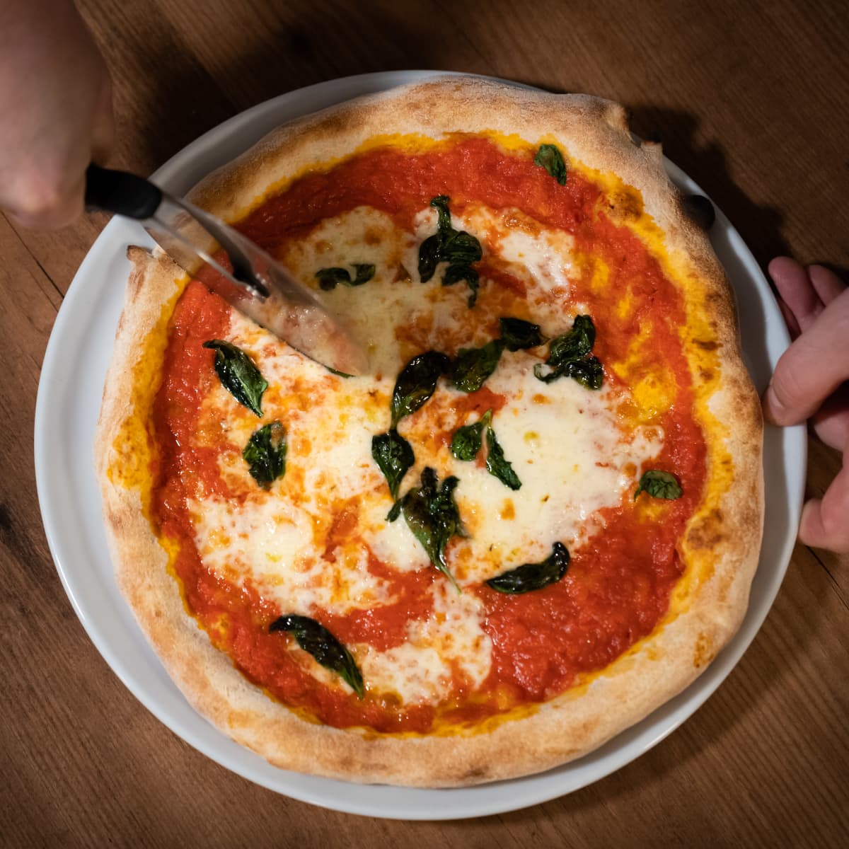 Pizzaa leikataan leikkurilla.
