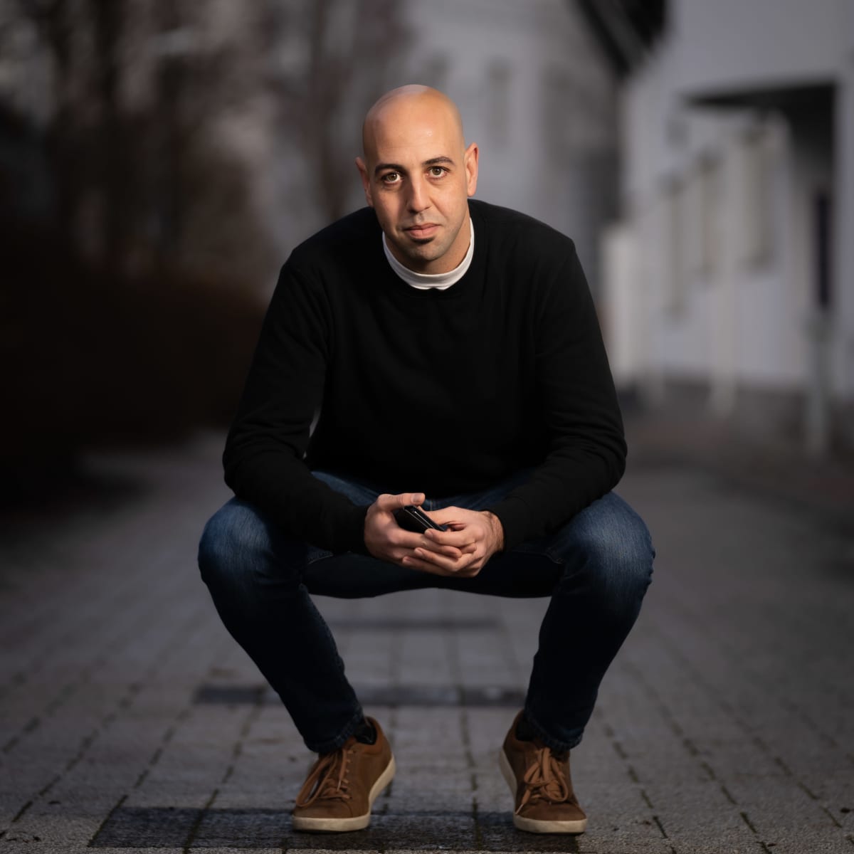 Luay Helal kyykyssä kadulla henkilökuvassa.