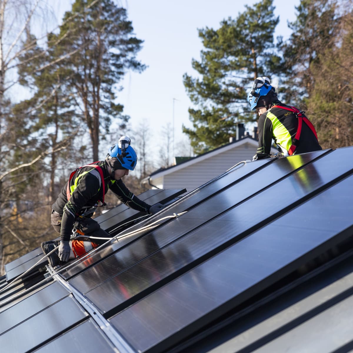Solarvoima Oy:n asentajat Joni Särkinen ja Erik Aho asentavat aurinkopaneeleja omakotitalon katolle.