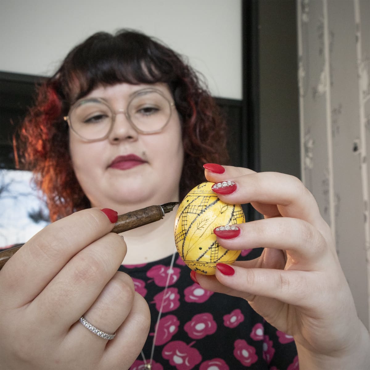 Hanna Lintu maalaa keltaista pääsiäismunaa.