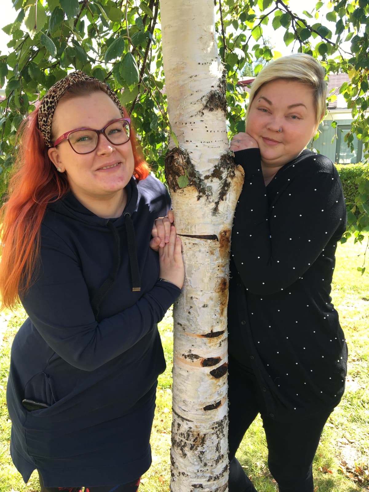 Jenni Hannula ja Annika Pehkonen seisovat koivun vieressä.