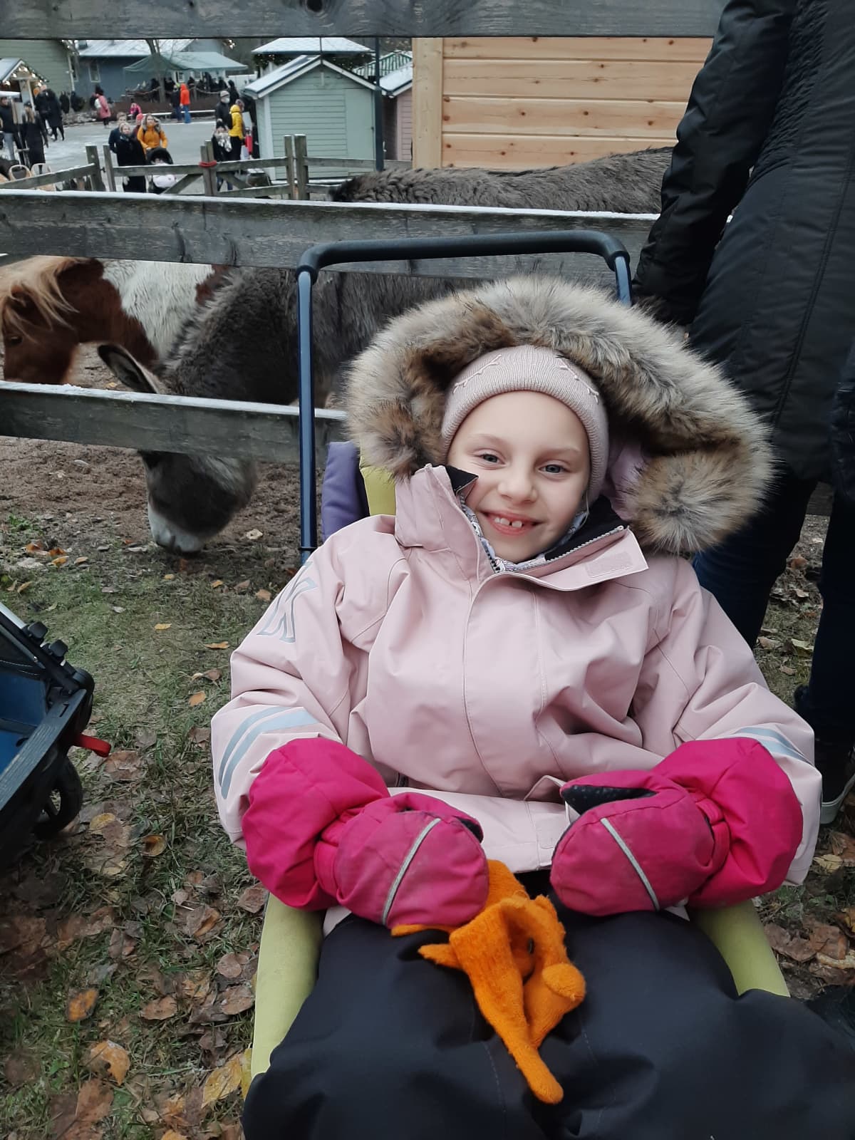 Koululaistyttö istuu lastenrattaissa