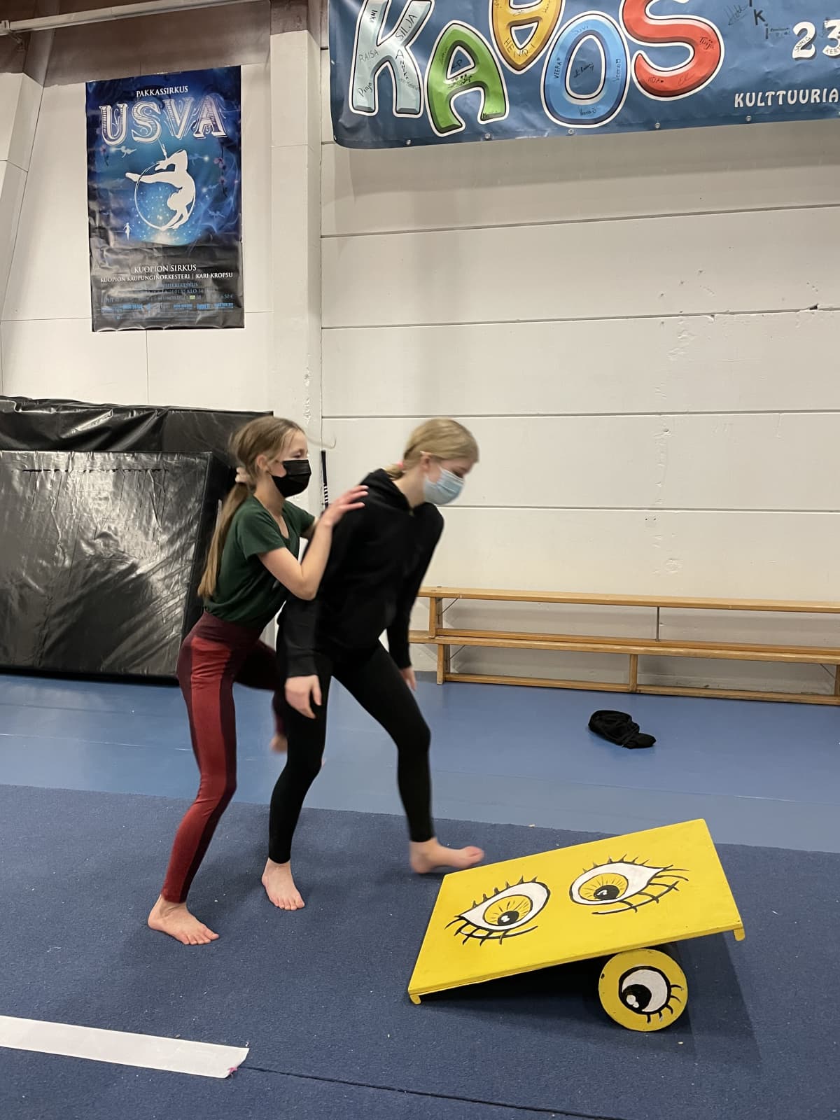 Kaksi nuorta menossa tasapainolaudan päälle.