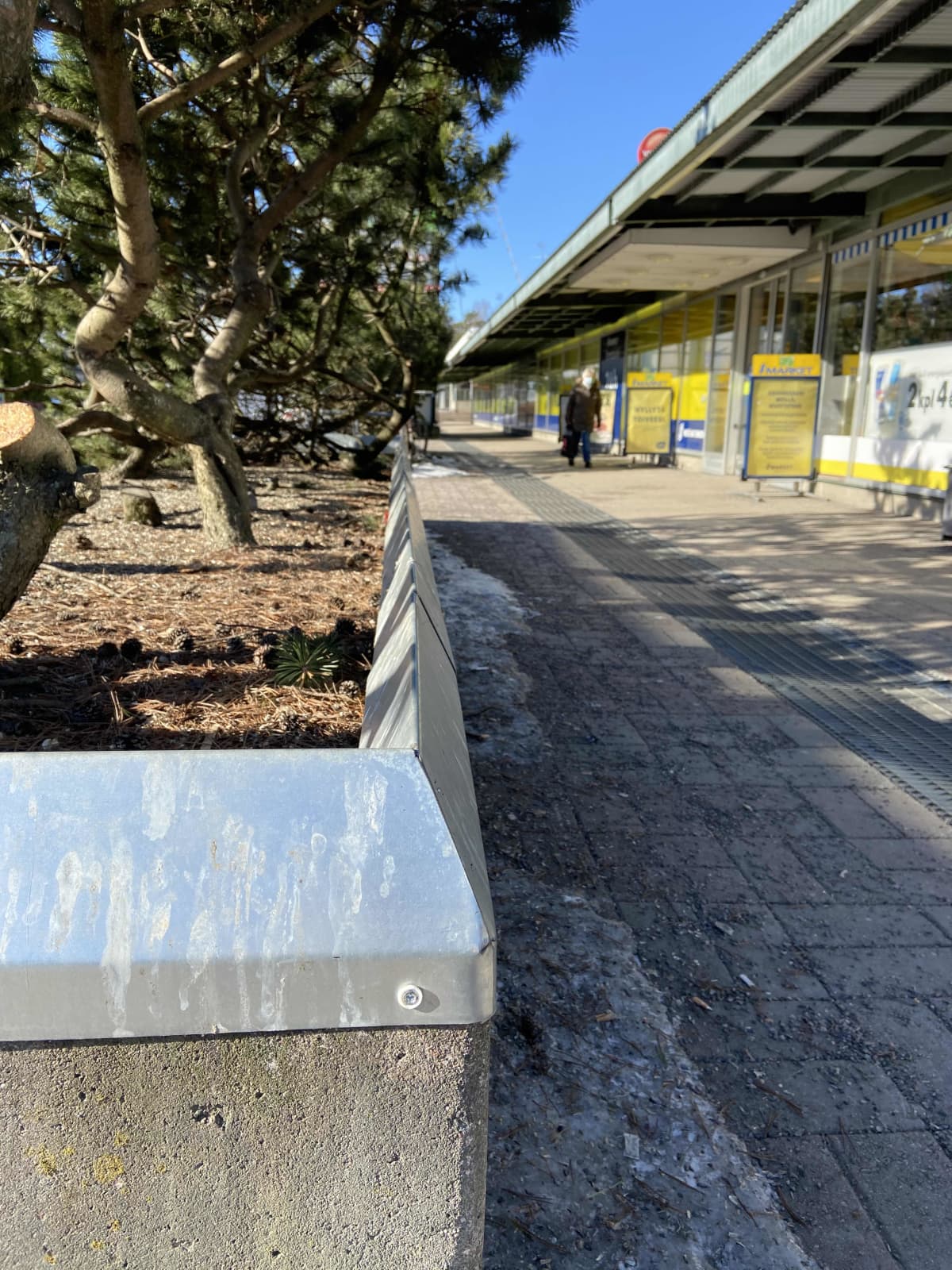 Metallinen teräväkulmainen istumaeste Munkkivuoren ostoskeskuksella