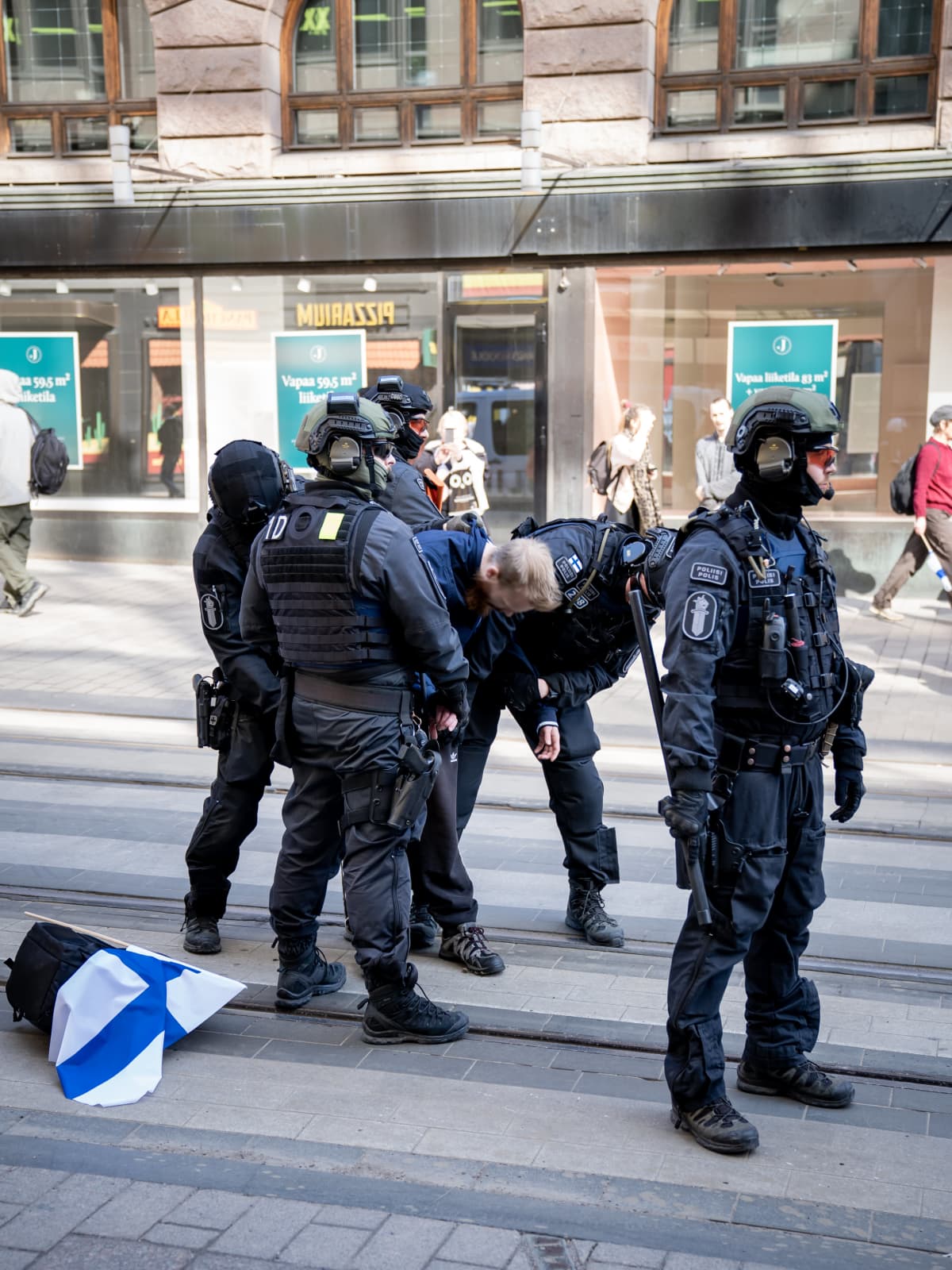 Poliisi ottaa kiinni mielenosoittajan