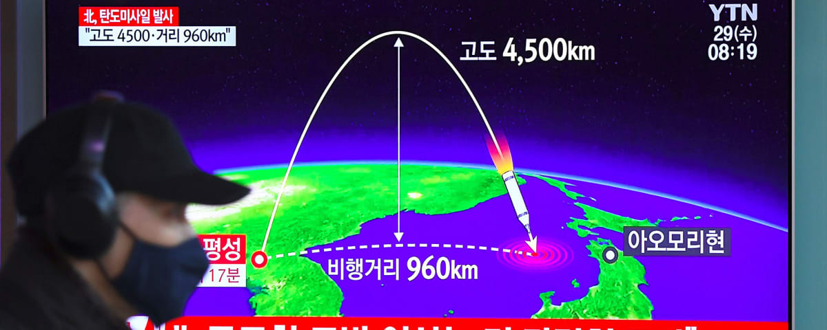 Mies kävelee Soulin rautatieasemalla televisioruudun ohitse, jossa näkyy Pohjois-Korean ohjuskoetta analysoiva grafiikka.