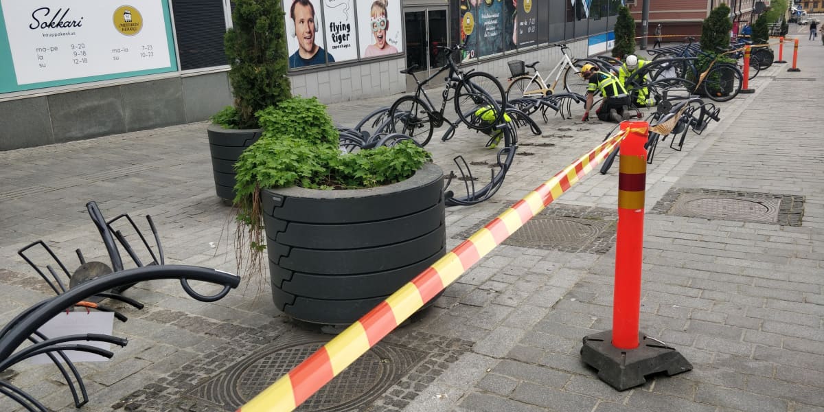 Työmiehiä purkamassa pyörätelineitä Jyväskylän Asemakadulla.
