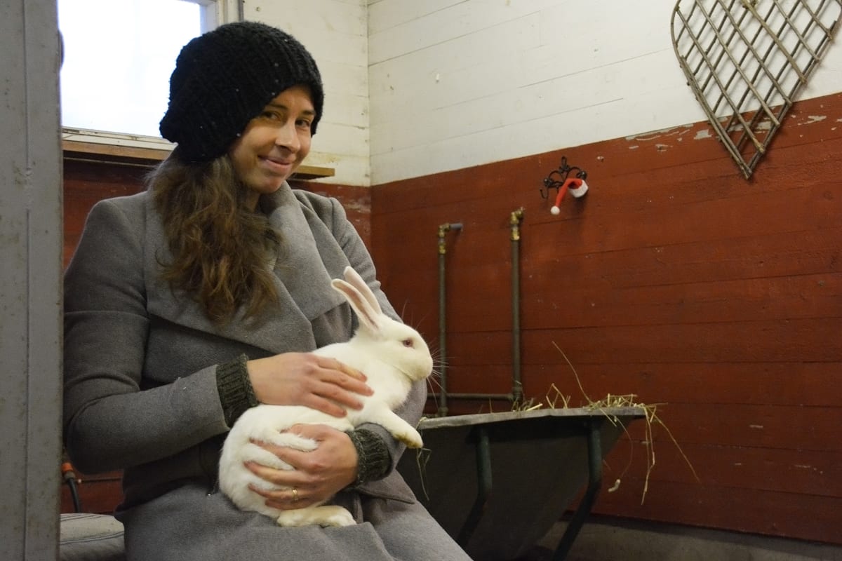 Liisa Koivisto istuu kani sylissään.