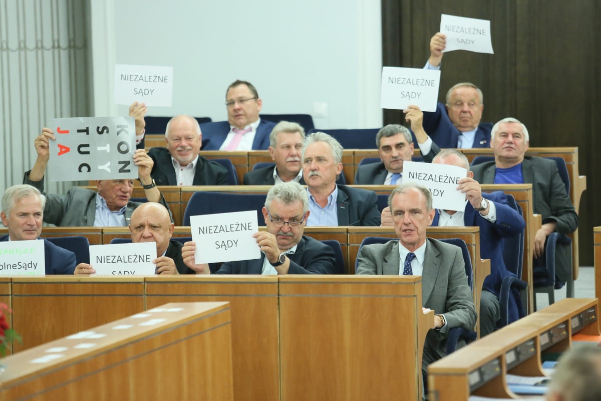 Lakiehdotusta vastustavat senaattorit heiluttavat lappuja, joissa lukee "itsenäinen oikeuslaitos" Puolan senaatissa 22. heinäkuuta 2017.