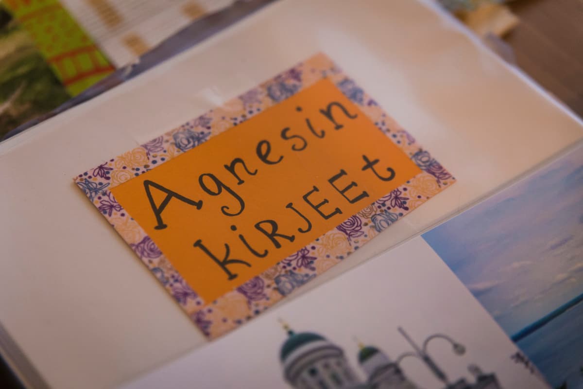 Nina Nieminen pitää Agnesista kansiota, joka on viimeisen neljän vuoden aikana täyttynyt kummitytön kirjeistä ja piirustuksista.