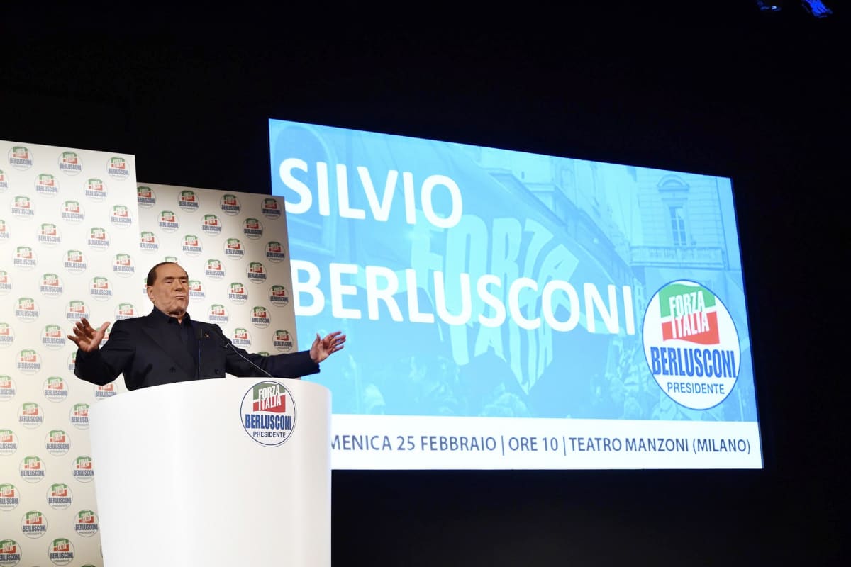 Silvio Berlusconi puhujanpöntössä, lavan taustalle on heijastettu hänen nimensä.