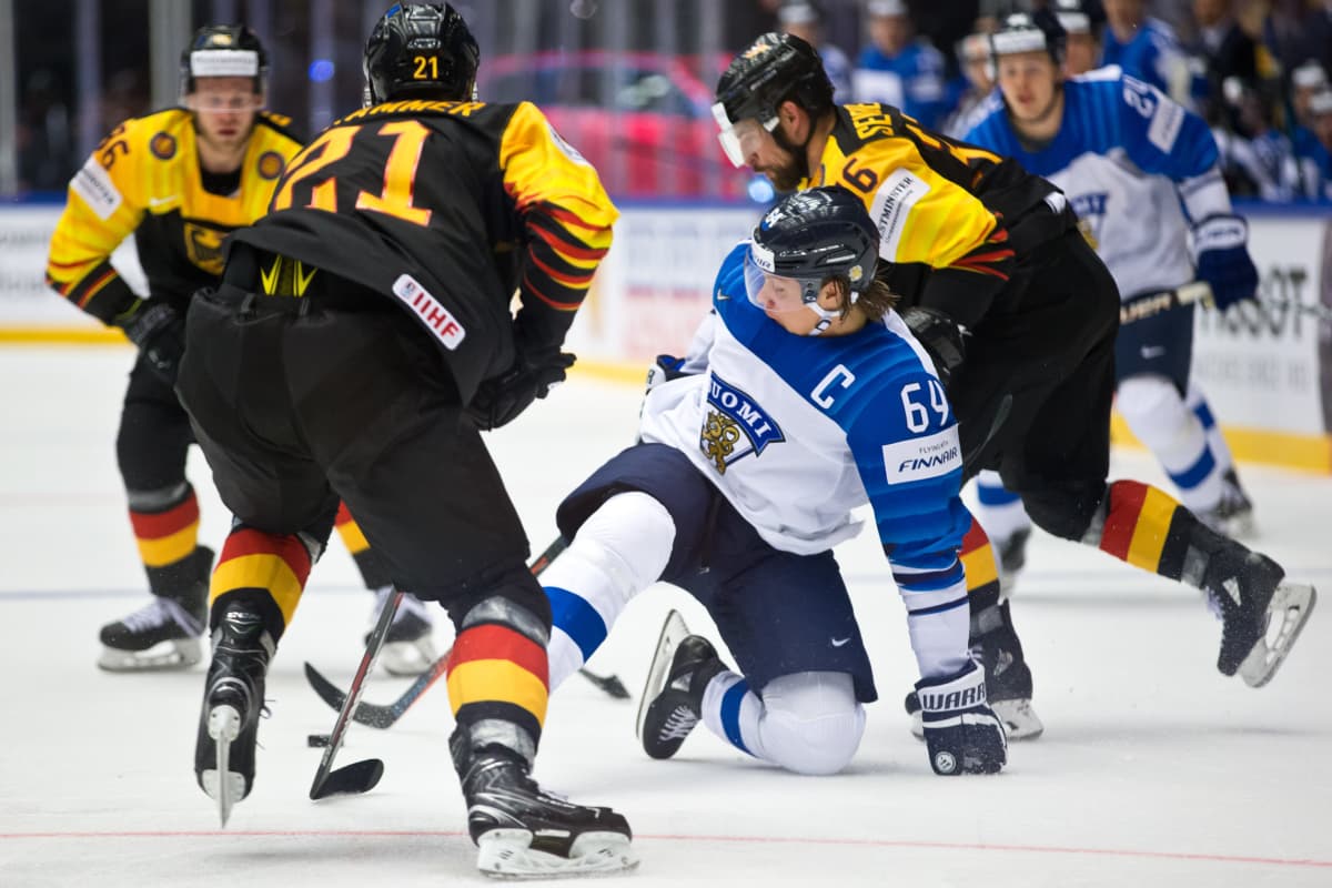 Mikael Granlund kaatuu saksalaispelaajien keskellä MM-kisoissa.