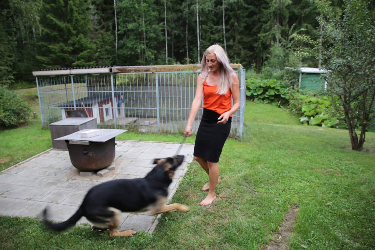 Laura Salmela leikkii koiransa kanssa.