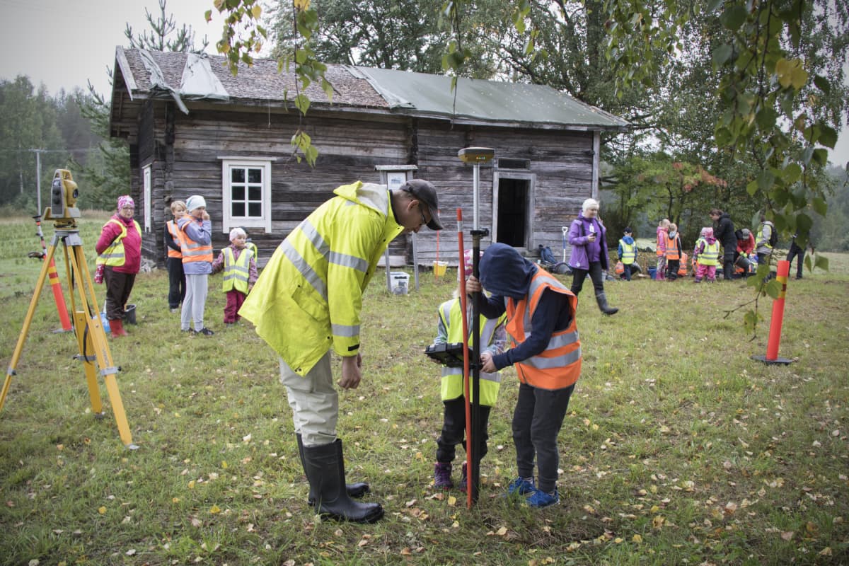 Koululaiset mittaavat vanhan talon pihapiiriä Kontiolahdella.