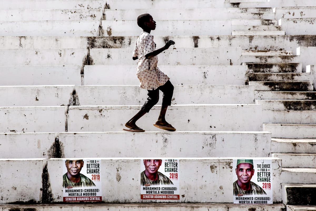 Poika tanssii valkoisilla portailla Jimetassa, Nigeriassa.
