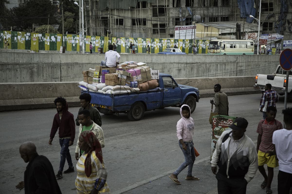 Ihmisiä ja ajoneuvoja kadulla Addis Abeban keskustassa.
